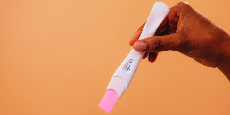 An image of a hand holding a pregnancy test